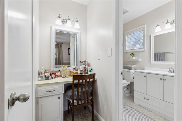 bathroom featuring tile patterned floors, toilet, vanity, and baseboards