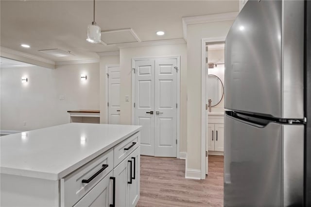 kitchen with ornamental molding, recessed lighting, light wood-style flooring, freestanding refrigerator, and white cabinets