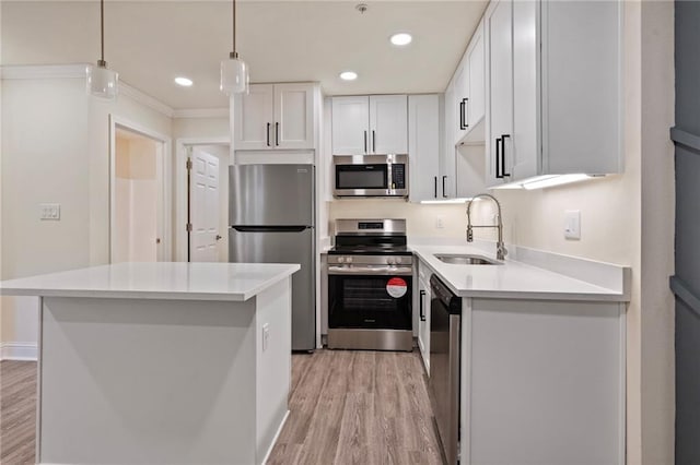 kitchen featuring light wood-style flooring, white cabinets, appliances with stainless steel finishes, and a sink