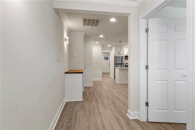 hall with visible vents, ornamental molding, recessed lighting, light wood finished floors, and baseboards