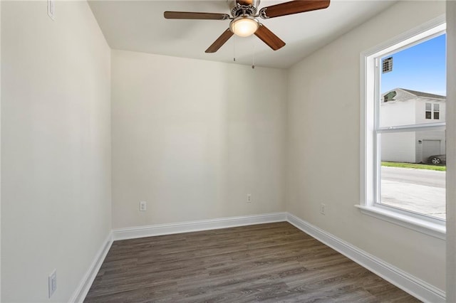 unfurnished room with baseboards, dark wood-type flooring, and a ceiling fan