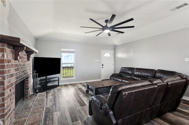 living area with visible vents, baseboards, wood finished floors, and a fireplace