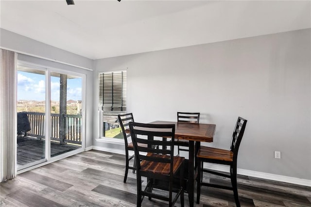 dining space featuring baseboards and wood finished floors