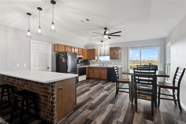 kitchen with electric range, visible vents, freestanding refrigerator, a peninsula, and light countertops