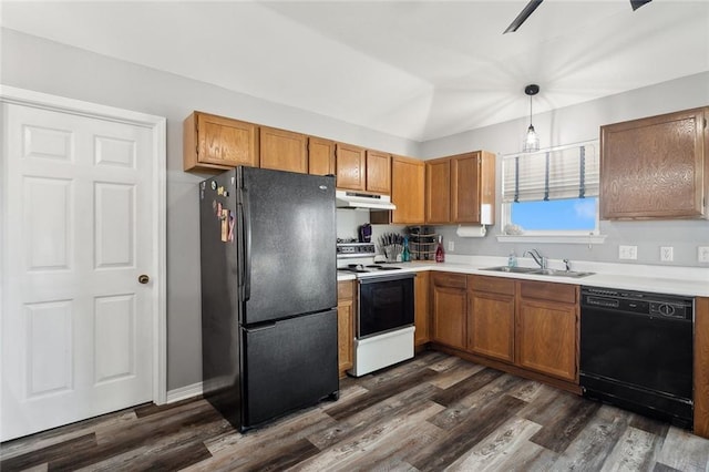 kitchen with brown cabinets, black appliances, a sink, under cabinet range hood, and dark wood-style flooring