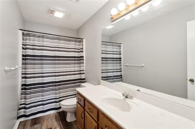 full bathroom featuring vanity, a shower with curtain, wood finished floors, visible vents, and toilet