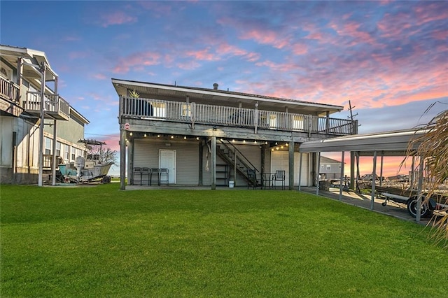 rear view of house with a deck, stairway, and a yard