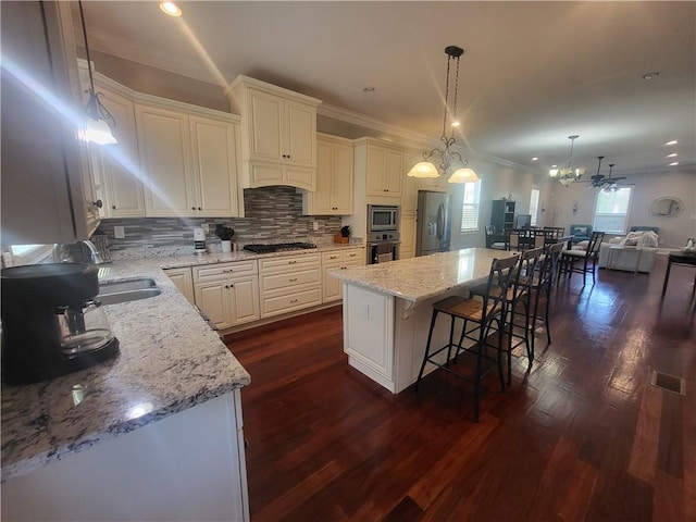 kitchen with dark wood-type flooring, a breakfast bar, tasteful backsplash, open floor plan, and stainless steel appliances