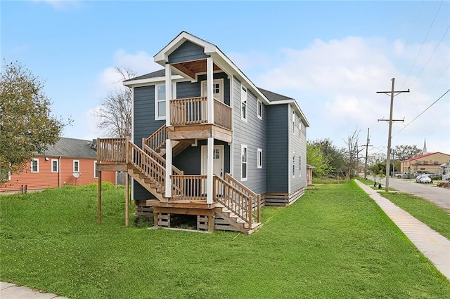 rear view of house with stairway and a yard