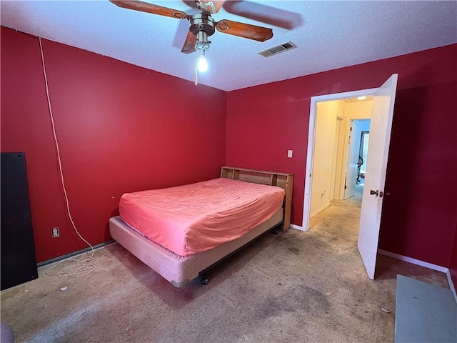 carpeted bedroom with baseboards, visible vents, a textured ceiling, and ceiling fan