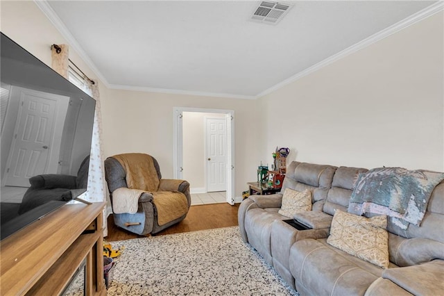 living room featuring visible vents, wood finished floors, baseboards, and ornamental molding