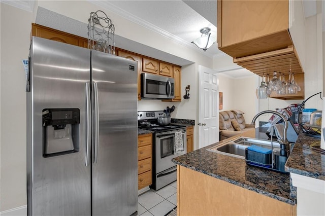 kitchen featuring crown molding, stainless steel appliances, light tile patterned flooring, a textured ceiling, and a sink