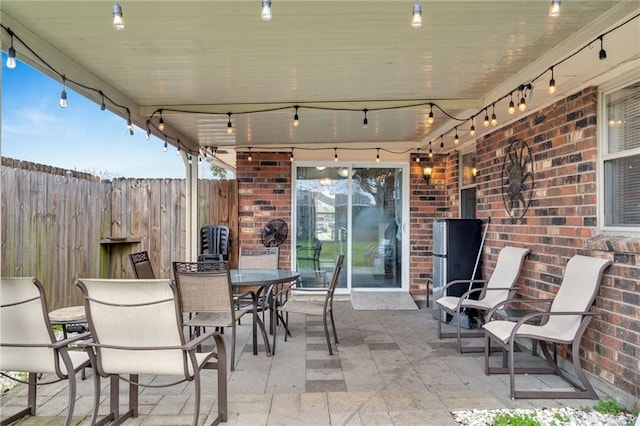 view of patio with outdoor dining space and fence