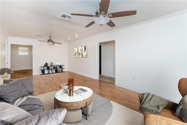 living room featuring crown molding, wood finished floors, visible vents, and baseboards