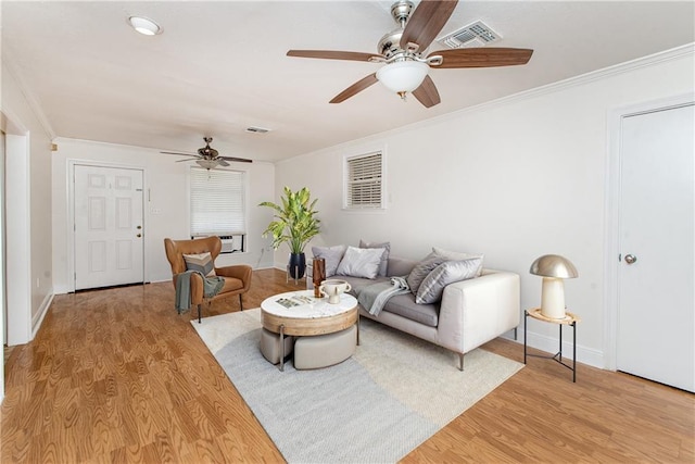 living room featuring light wood finished floors, visible vents, ceiling fan, and ornamental molding