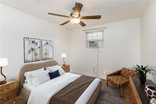 bedroom featuring cooling unit, a ceiling fan, baseboards, and a textured ceiling