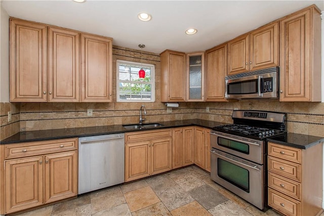 kitchen featuring dark countertops, appliances with stainless steel finishes, and a sink