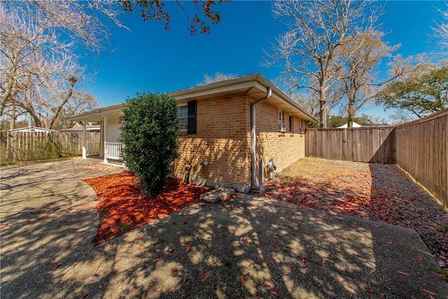 view of property exterior with brick siding and a fenced backyard