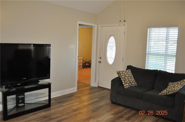 living room with vaulted ceiling, wood finished floors, and baseboards