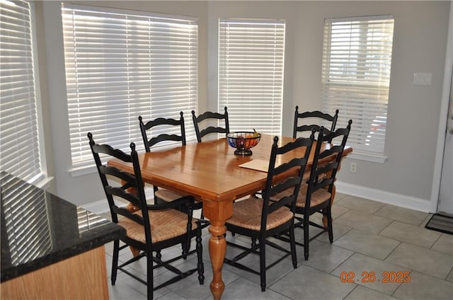 dining area with baseboards and light tile patterned flooring