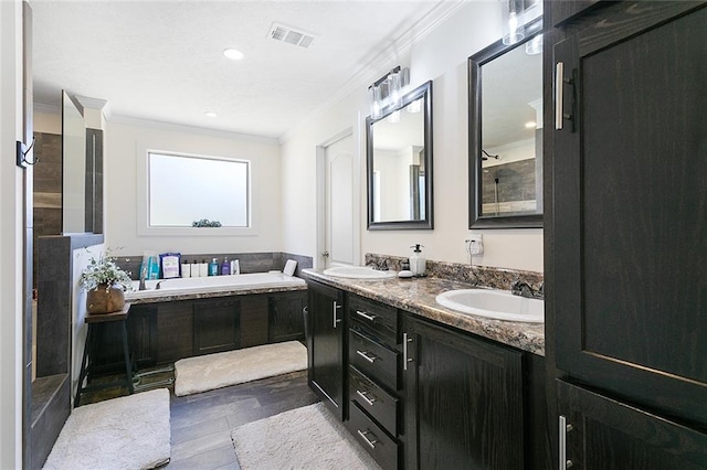 full bath with a sink, visible vents, a bath, and crown molding