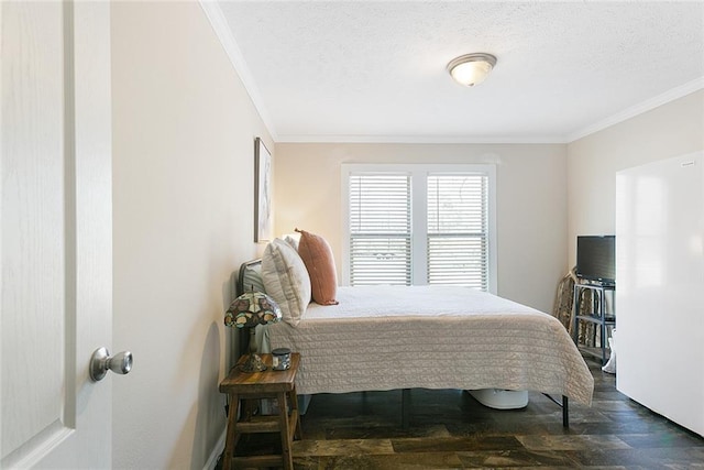 bedroom featuring a textured ceiling, wood finished floors, and ornamental molding