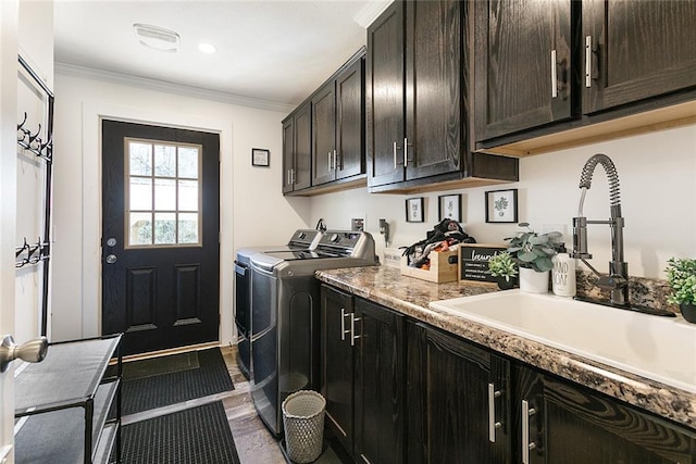 clothes washing area featuring ornamental molding, a sink, washer and dryer, dark wood-style floors, and cabinet space