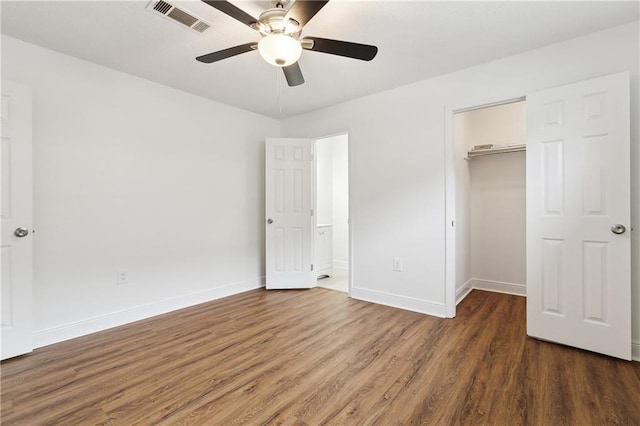 unfurnished bedroom with wood finished floors, visible vents, a closet, and baseboards