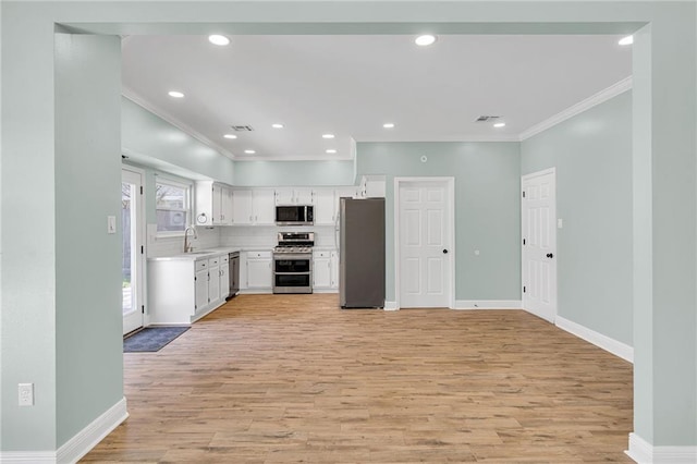 kitchen with light countertops, decorative backsplash, light wood-style flooring, stainless steel appliances, and a sink