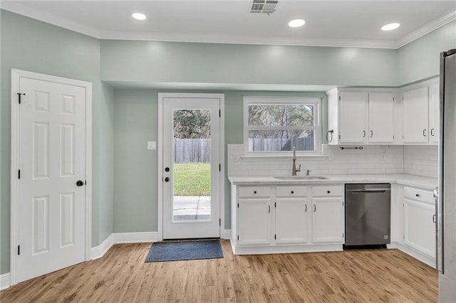 kitchen with light wood-style flooring, a sink, tasteful backsplash, stainless steel dishwasher, and light countertops