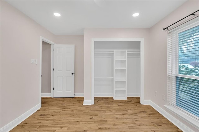 unfurnished bedroom with recessed lighting, a closet, baseboards, and light wood-style flooring