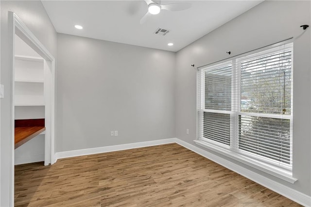 unfurnished room featuring visible vents, ceiling fan, baseboards, and wood finished floors