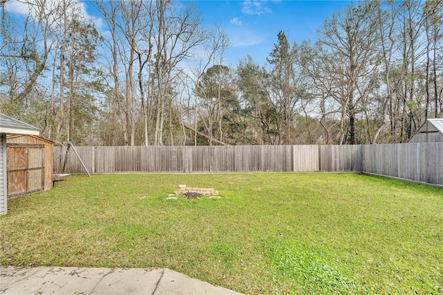 view of yard featuring a storage unit, an outdoor structure, and a fenced backyard