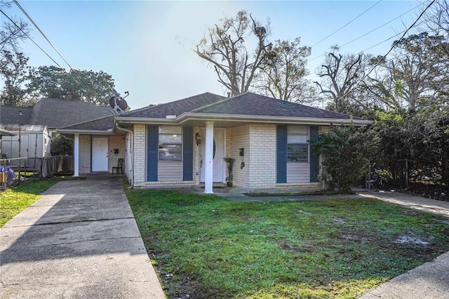 bungalow-style house featuring a front lawn, fence, brick siding, and a shingled roof