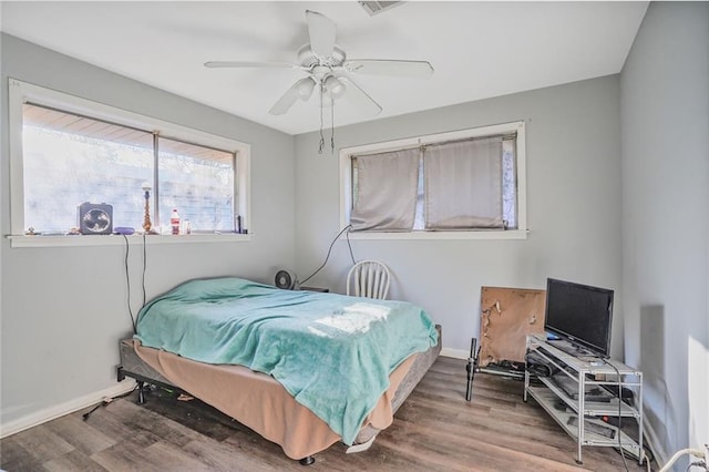 bedroom featuring a ceiling fan, baseboards, and wood finished floors