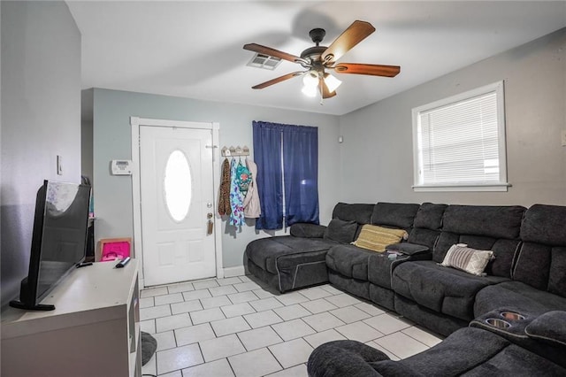 living room with light tile patterned floors, visible vents, and ceiling fan