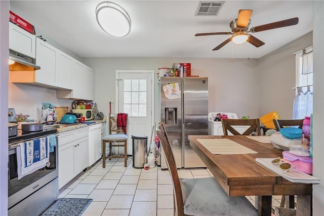 kitchen featuring visible vents, under cabinet range hood, appliances with stainless steel finishes, light countertops, and light tile patterned floors