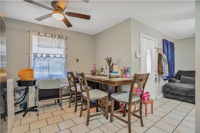 dining room with light tile patterned floors, baseboards, and ceiling fan