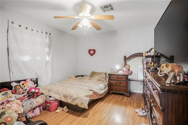 bedroom with visible vents, light wood-style flooring, and a ceiling fan