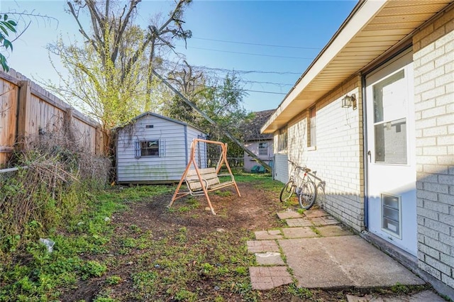 view of yard with an outdoor structure, a shed, and fence