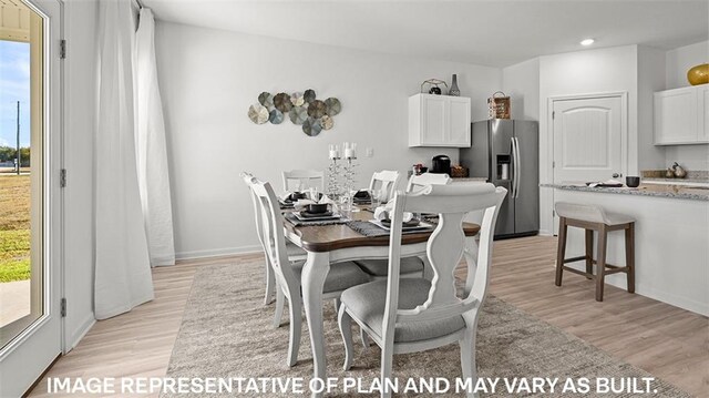 dining space with light wood finished floors and recessed lighting