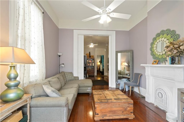 living room with a fireplace, a ceiling fan, and wood finished floors