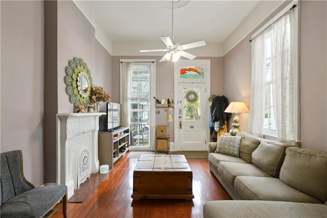 living area with a ceiling fan and dark wood-style flooring