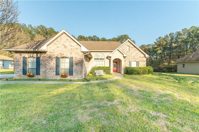 view of front of home with a front yard and brick siding