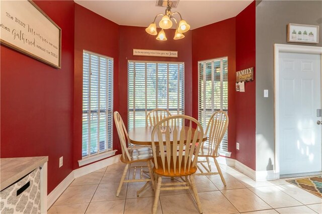 dining area featuring a notable chandelier, light tile patterned floors, and baseboards