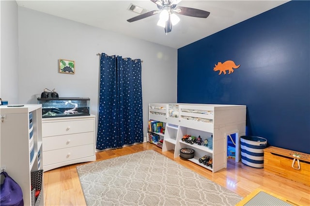 bedroom featuring visible vents, wood finished floors, and a ceiling fan