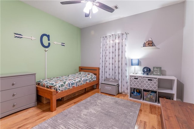 bedroom featuring wood finished floors, visible vents, and ceiling fan