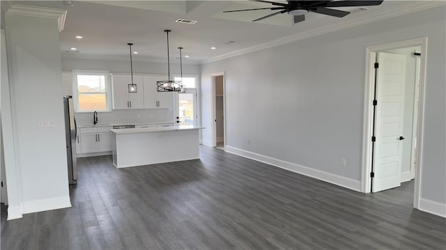 kitchen with visible vents, a kitchen island, white cabinets, open floor plan, and backsplash