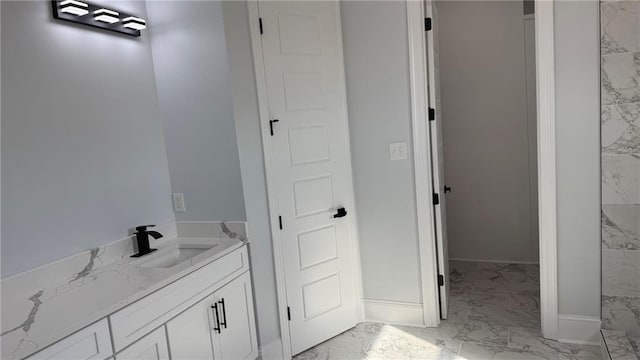 bathroom featuring baseboards, marble finish floor, and vanity