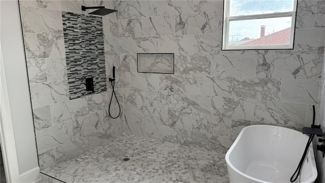 full bath with a freestanding tub and a tile shower